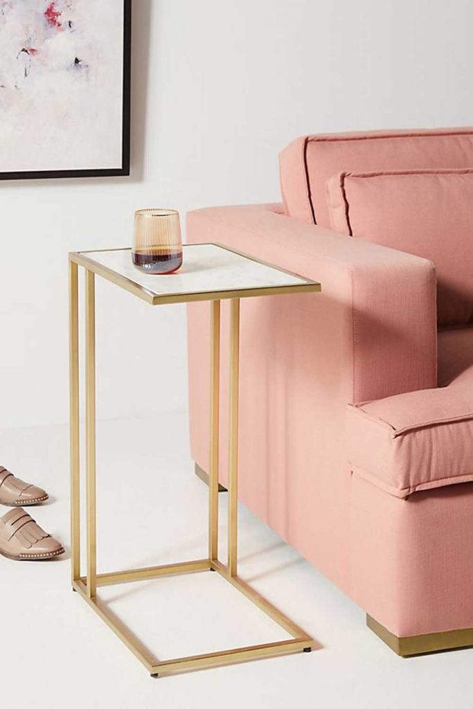 Marble and brass side table beside pink sofa